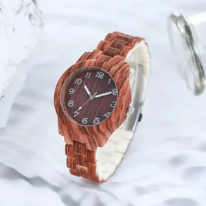 Détail d'une montre à quartz en bois sombre avec chiffres arabes et bracelet à maillons
