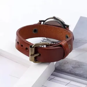 Detail of vintage brown leather watch strap with bronze buckle and polished case back