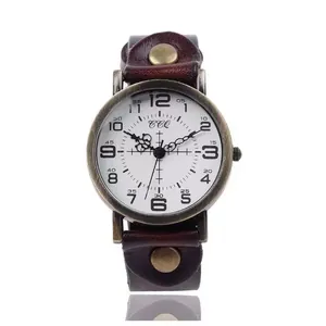 Macro detail of retro bronze watch case with brown leather rivet strap and white dial