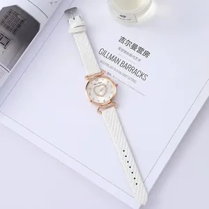 Detail of white leather strap watch featuring heart-shaped crystal dial and gold case