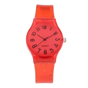 Detail view of red translucent jelly watch showing Arabic numeral dial and quartz crown