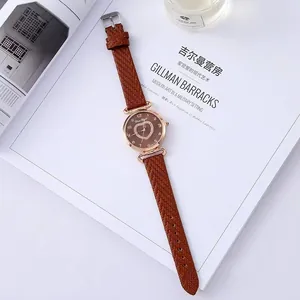 Detail of quartz watch with brown leather strap and diamond heart pattern on the dial