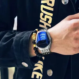 Close-up of men's watch with blue faceted glass and beaded bracelet on wrist