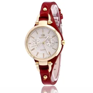 Detailansicht einer roten Lederuhr für Damen mit goldenem Gehäuse und weißem Zifferblatt