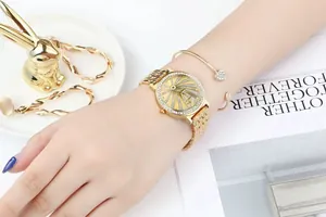 Detail of gold quartz watch with diamond-set dial and elegant chain strap on wrist