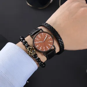 Macro view of men's black leather quartz watch set with woven and beaded bracelets