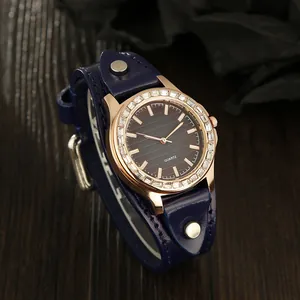 Detail of rose gold quartz watch with crystal bezel and blue leather bund strap