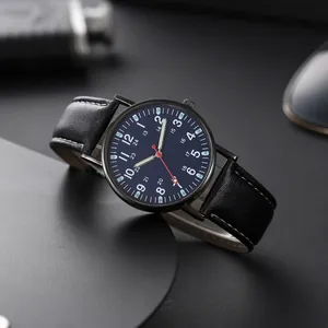 Macro shot of a navy blue watch dial with luminous markers and black leather strap details