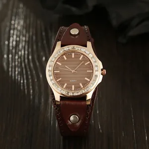 Close-up of brown leather wristband watch with rose gold case and sparkling crystals