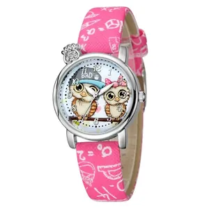 Dettaglio dell'orologio rosa per bambini con gufo, ciondolo di strass e cinturino scarabocchio
