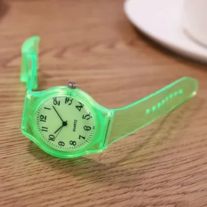 Close-up of green translucent quartz watch with Arabic numerals on wooden desk