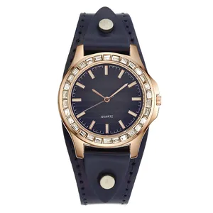 Macro detail of rose gold watch case with crystal bezel and blue leather strap texture