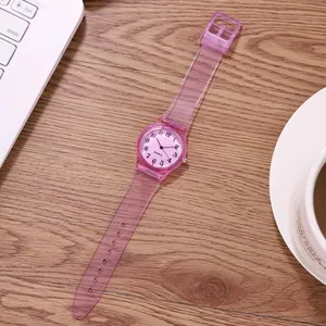 Detail of pink transparent silicone watch case and digital dial on a wooden table