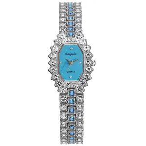 Macro shot of silver crystal-encrusted octagonal watch with light blue glitter dial texture