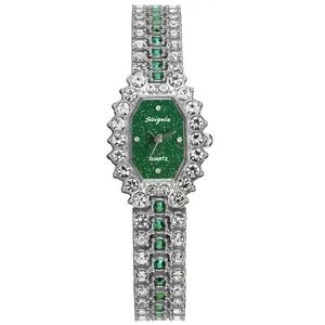 Detailed close-up of a silver-tone luxury quartz watch with green dial and crystals