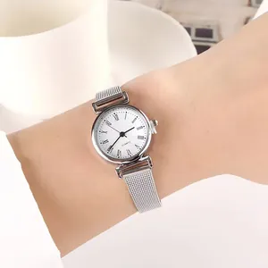 Close-up of elegant silver mesh strap quartz watch with Roman numerals on female wrist
