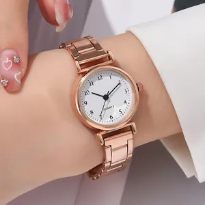 Détail de la montre à quartz en or rose avec cadran blanc et chiffres au poignet féminin
