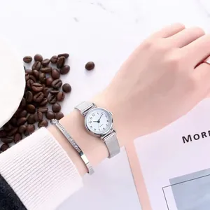Close-up of elegant small silver mesh watch with a matching sparkling rhinestone bracelet