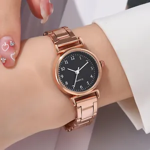 Gros plan d'une montre en acier or rose avec cadran noir et chiffres blancs au poignet