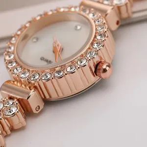 Primo piano della lunetta dell'orologio in oro rosa con cristalli e quadrante bianco