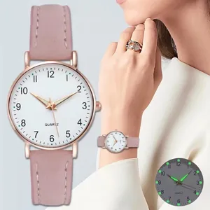 Dettaglio delle lancette luminose e cinturino in pelle smerigliata rosa su orologio
