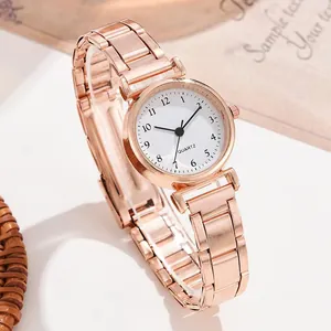 Détail d'une montre à quartz or rose avec cadran blanc et bracelet en métal