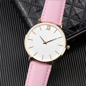 Close-up of minimalist rose gold watch with white dial and pink leather strap texture