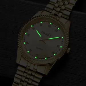Detailopname van gouden horloge met lichtgevende groene wijzers en strass-indexen