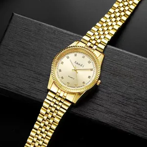 Macro-opname van gouden quartzhorloge met strass steentjes op zwarte geschenkdoos