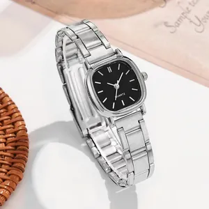 Gros plan d'une montre à quartz argentée carrée avec cadran noir sur fond minimaliste