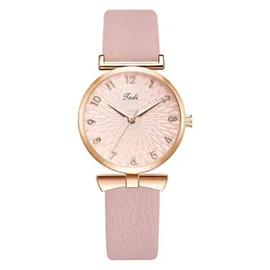 Detail van roze lederen band en roségouden quartzhorloge met een zonnestraal-textuur wijzerplaat