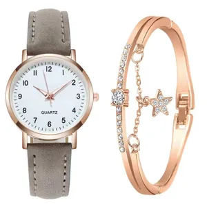 Dettaglio dell'orologio oro rosa con cinturino in pelle grigia e bracciale con stella
