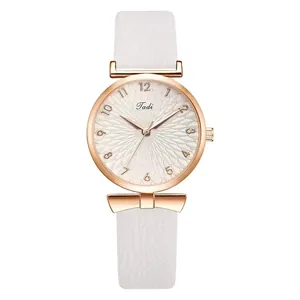 Detailopname van het roségouden horloge met witte leren band en zonnebloem wijzerplaat