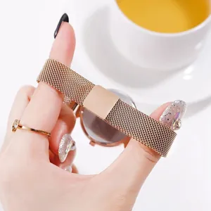 Detailed view of rose gold Milanese watch band and square clasp on woman's wrist