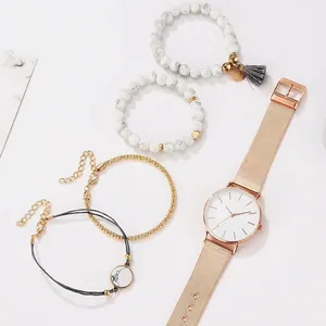 Détail de la montre à quartz en or rose avec cadran épuré et bracelet de perles marbre