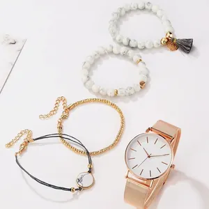 Gros plan sur le coffret montre or rose avec bracelets en marbre et pompons