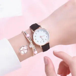 Detail of minimalist women's watch with black strap and floral beaded bracelet set