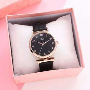 Close-up of Tadi leather watch with rose gold bow charm in a pink gift box