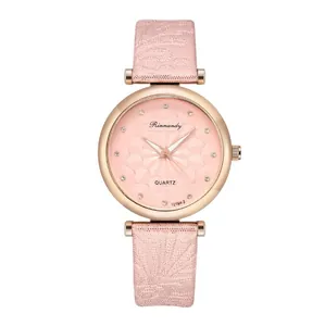 Detailed close-up of pink starry watch face with rhinestone markers and floral leather strap