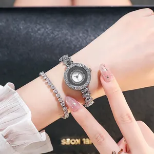 Nahaufnahme einer silbernen Damenuhr mit Diamantbesatz und passendem Armband am Handgelenk