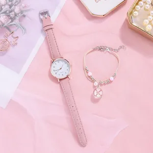 Close-up of a women's quartz watch and beaded floral bracelet set in soft pastel pink color