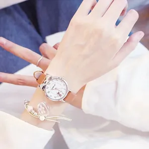 Nahaufnahme der süßen Katzenohr-Uhr mit braunem Lederarmband und Blumenarmband