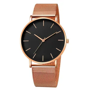 Détail du bracelet en maille or rose et cadran noir minimaliste de montre à quartz