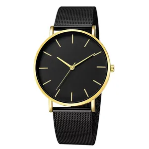 Détail du bracelet en maille acier noir et du boîtier rond poli doré de la montre luxe