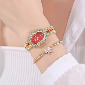 Gros plan d'une montre de luxe dorée et d'un bracelet papillon ornés de strass brillants