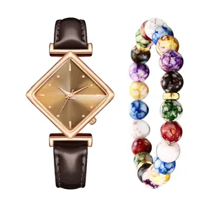 Details einer roségoldenen Uhr mit braunem Lederarmband und buntem Perlenarmband