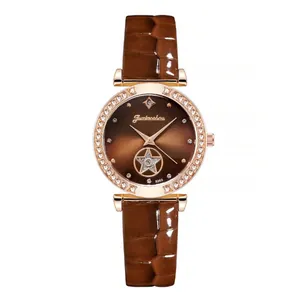 Detail of rose gold watch case with crystal bezel and brown sunray star dial