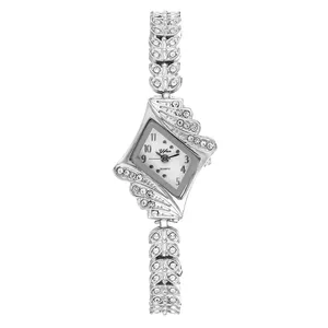 Detail of silver geometric diamond-shaped watch case with rhinestone wing accents