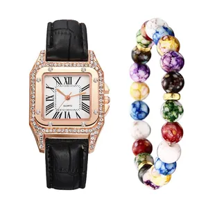Detail of rose gold square watch with black leather strap and colorful beaded bracelet