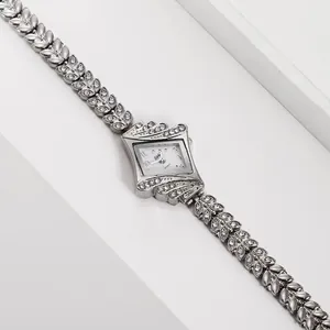 Close-up of silver quartz watch with diamond-set diamond case and leaf-shaped band